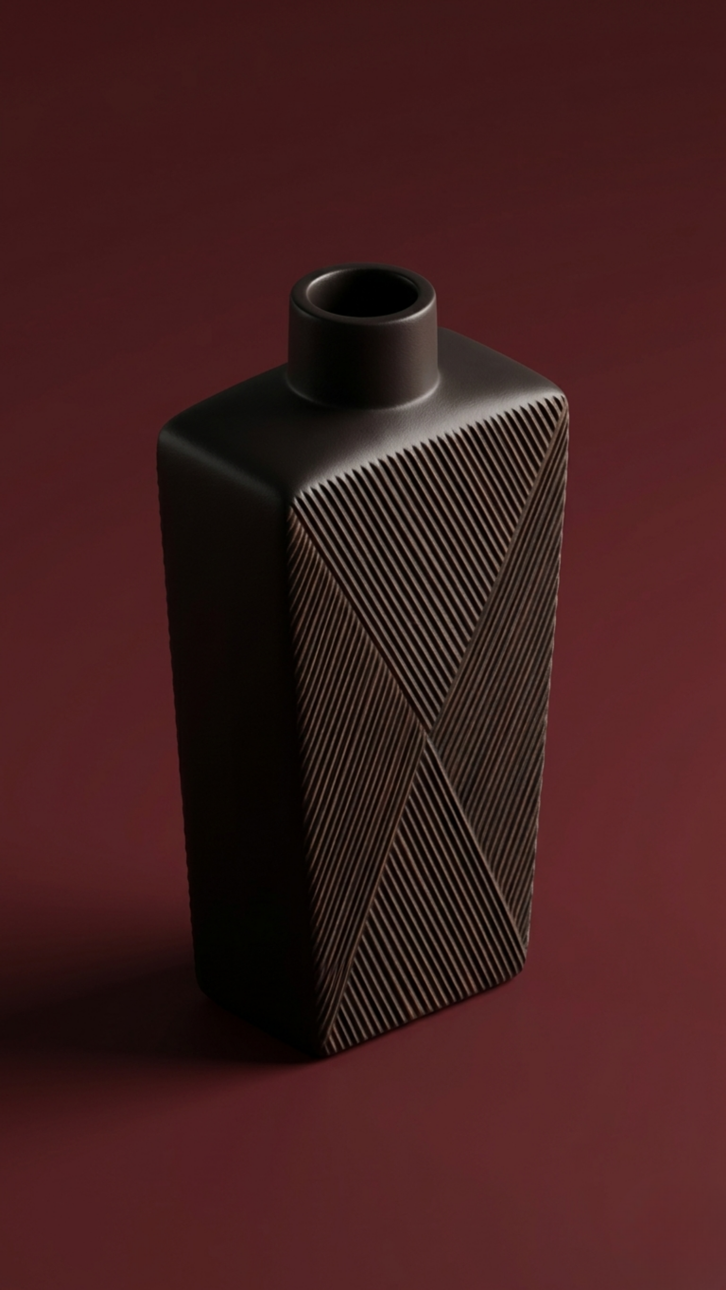 Mazaj Classic resin vase with geometric carved texture and matte dark finish, displayed against a deep red background in a minimal studio setting